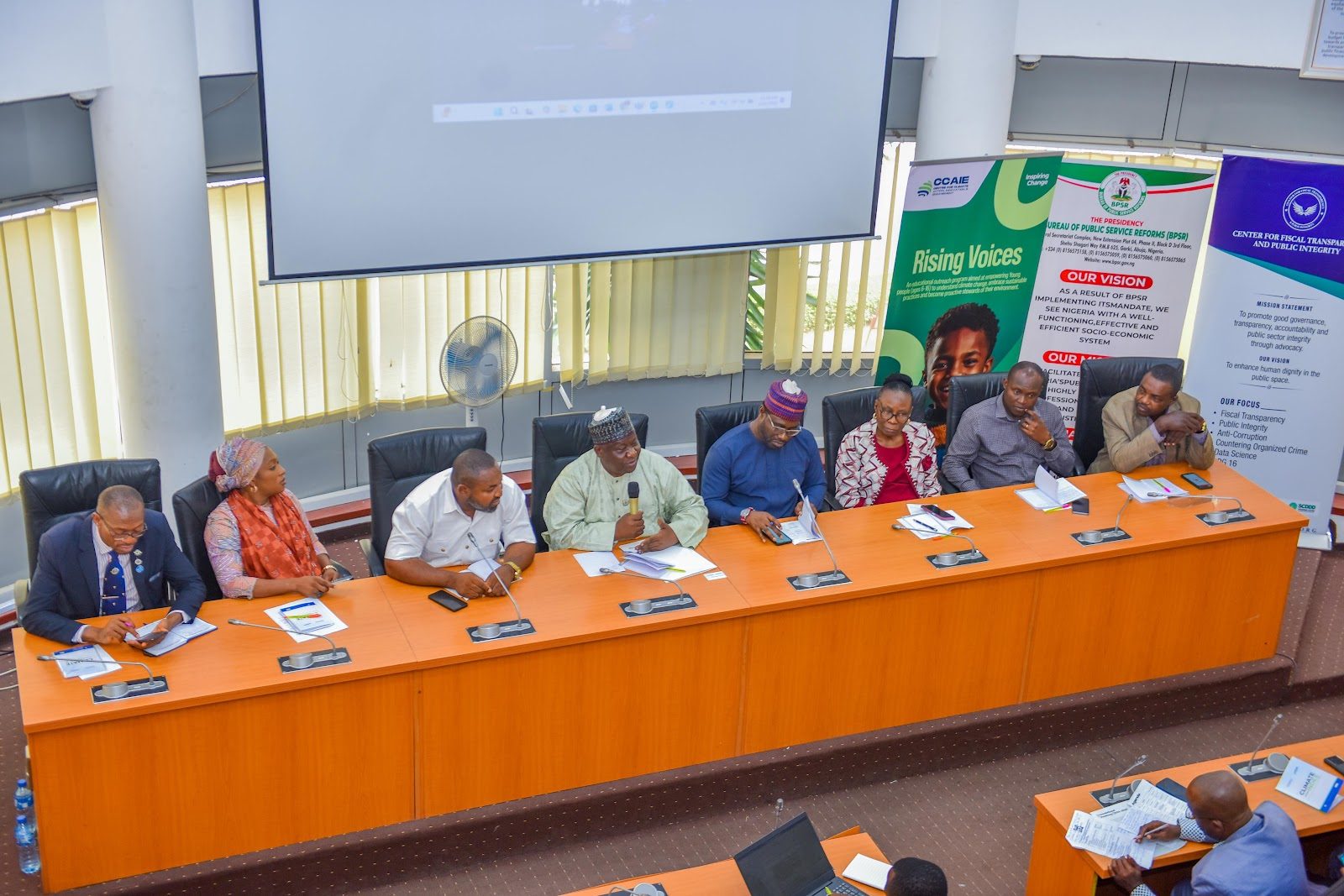 Panel of speakers seated at the front of the room