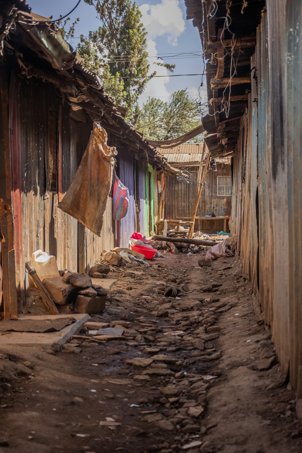 Narrow alley between wooden and corrugated-iron homes in an informal settlement (stock photo)